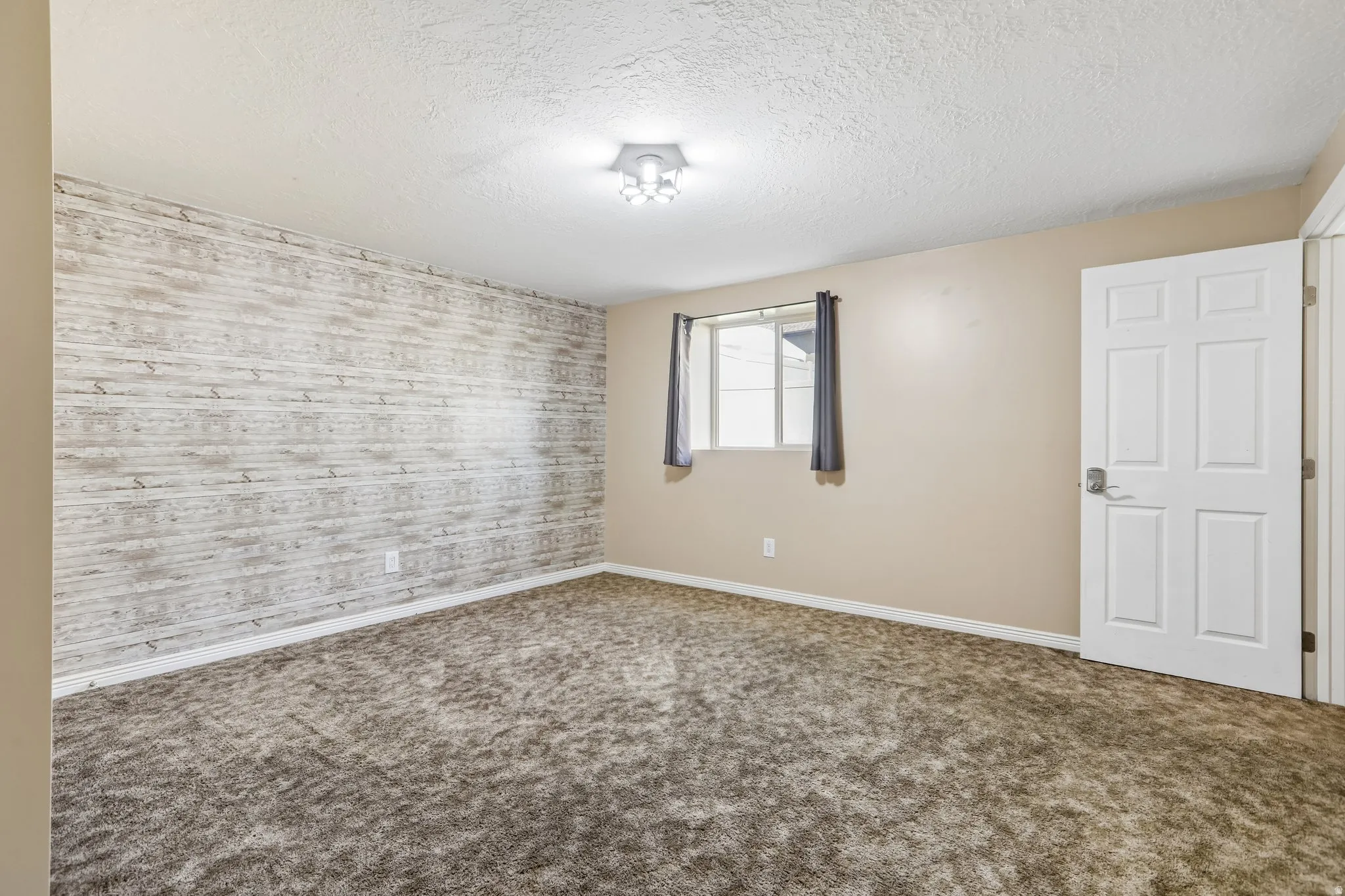 Neutral tone walls with an accent wall featuring a distressed wood-finish treatment