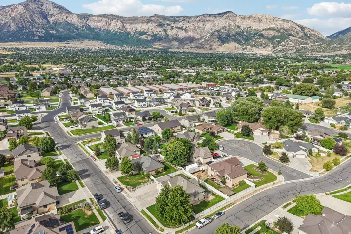 Residential neighborhood with established streets and mature landscaping, set against a mountainous backdrop