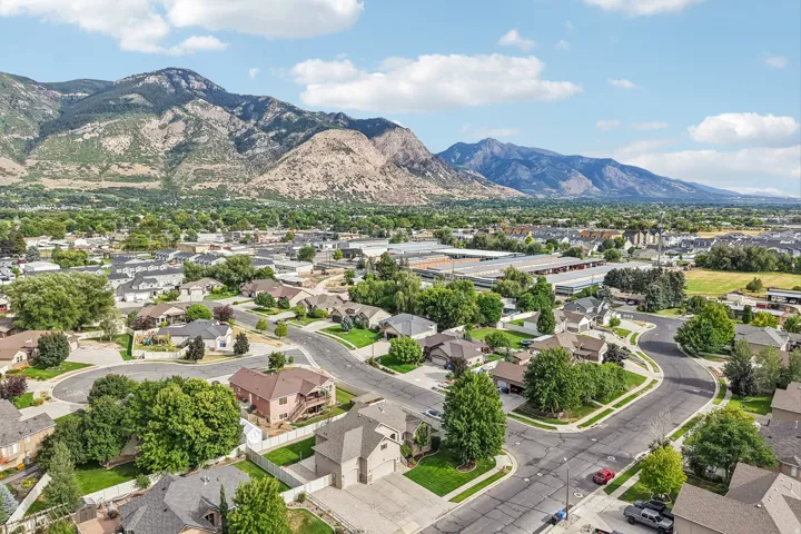 Residential neighborhood with established homes, mature trees, and mountainous backdrop