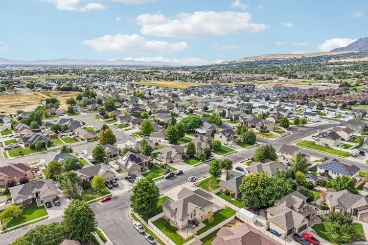 Residential neighborhood with mature trees, paved streets, and a mountain backdrop