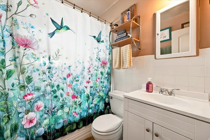 White tile wainscoting and a white vanity with a single basin sink