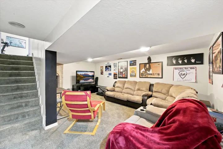 Carpeted flooring, recessed ceiling lighting, and a partial brick-finish wall