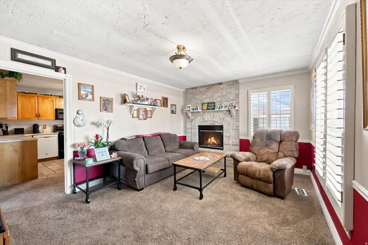 Brick fireplace with an arched mantel, recessed electric insert, and white crown molding