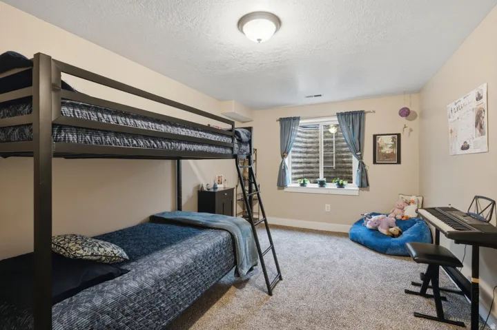 Neutral-toned walls, recessed window with blinds and drapes, and textured carpet flooring