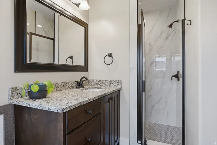 Dark wood-finish vanity with a light granite countertop