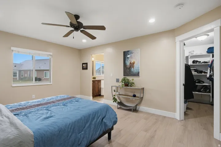 Recessed lighting, wood-finish flooring, ceiling fan, and a walk-in closet with built-in shelving