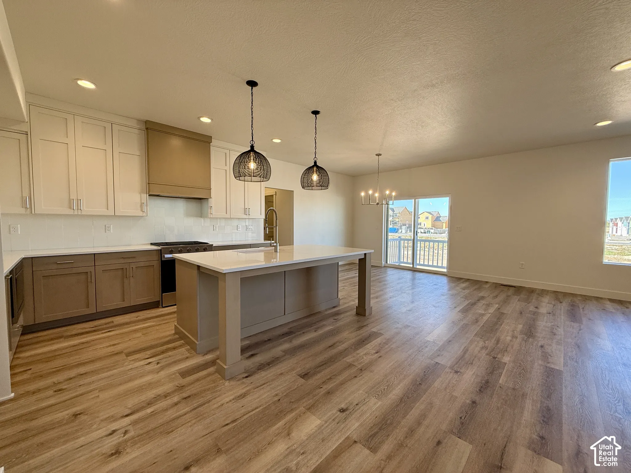 Kitchen featuring two-tone cabinetry, a matching range hood, a center island with a quartz countertop, recessed lighting, and wood-finish flooring
