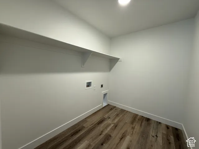 Wood-finish flooring, white walls, built-in shelving, and washer/dryer hookups