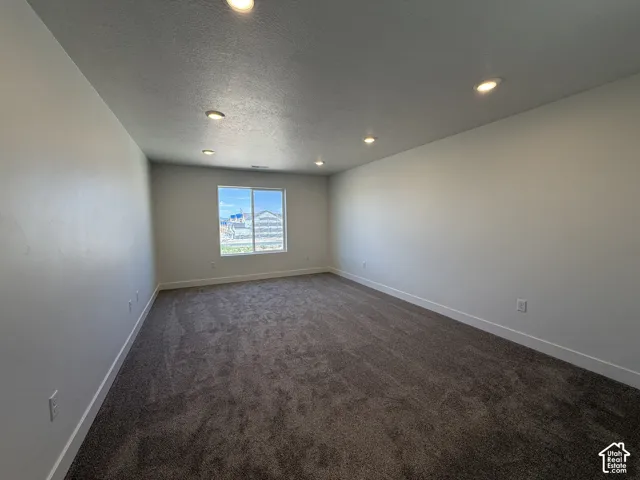 Recessed lighting, large window, neutral wall tones, and carpeted flooring
