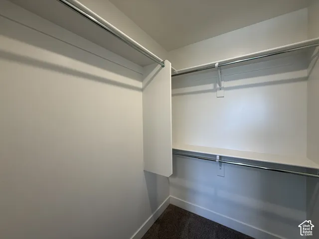 Built-in shelving with multiple chrome hanging rods and white walls