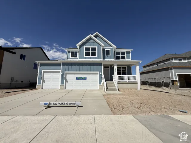 Two-story exterior with siding, a covered porch, white columns, and a two-car garage
