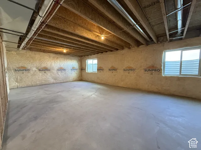 Unfinished basement with concrete flooring and exposed ceiling joists