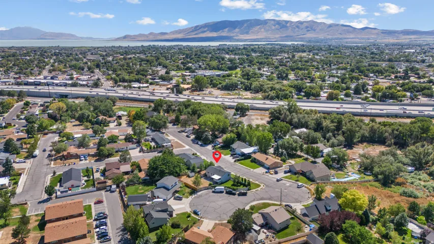 Aerial perspective showcasing a residential neighborhood with surrounding infrastructure and a distant body of water