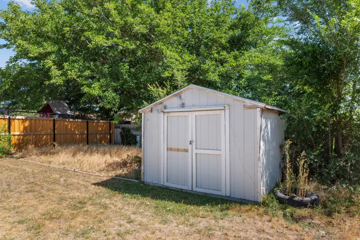 White-painted storage shed with double doors