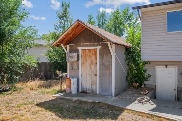 Detached storage shed with a gabled roof and wood-finish siding