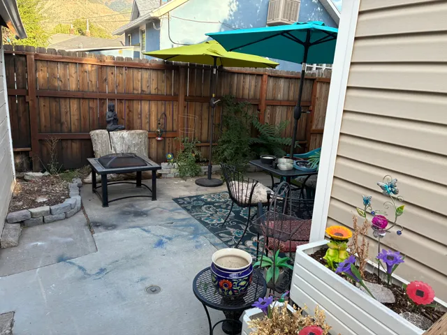 Private outdoor patio space featuring concrete surfacing and a wood privacy fence