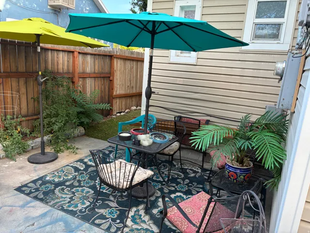 Private outdoor patio area with a wood fence, concrete paving, and a patch of green space