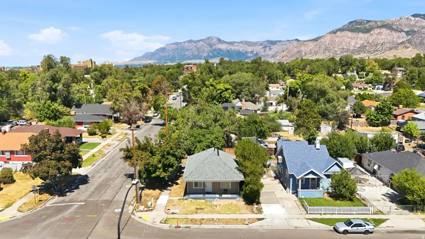 Residential neighborhood with mature trees and mountain backdrop