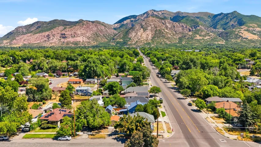 Expansive natural mountain backdrop with a tree-lined residential area