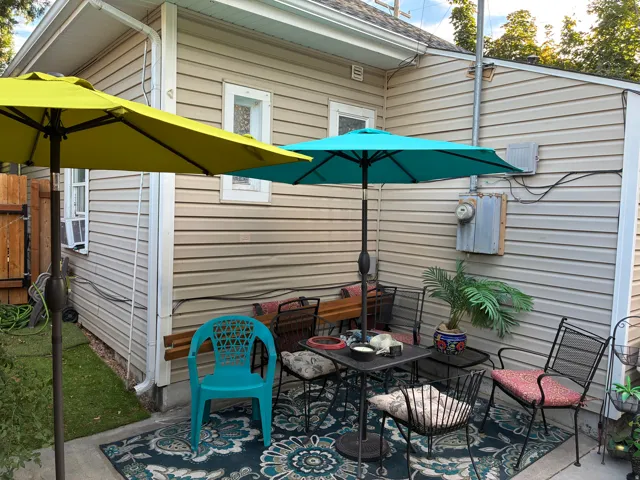 Paved patio area, horizontal siding, and a wooden fence