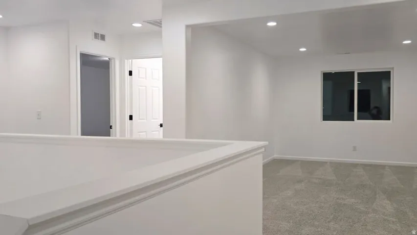 Neutral wall finishes, recessed lighting, carpet flooring, window, and interior doors