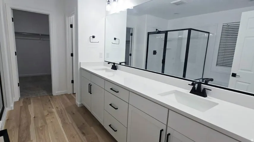 Dual vanity with white cabinetry, matte black hardware, and integrated sinks
