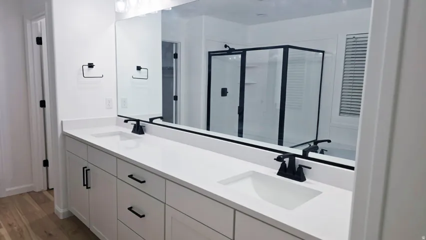 Dual vanity with white cabinetry, matte black hardware, and integrated rectangular sinks