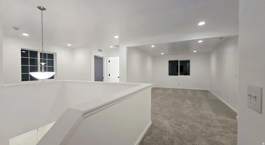 Carpeted room featuring recessed lighting and a window