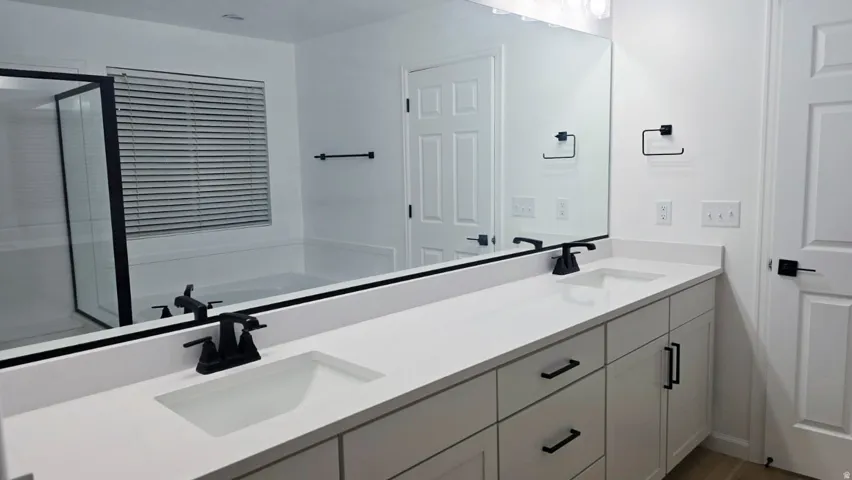 Dual vanity with undermount sinks, white countertop, and matte black fixtures
