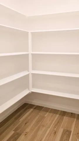 Built-in shelving with multiple storage levels and wood-finish flooring