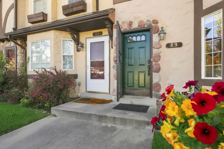 Stucco exterior with stone accents, covered entrance, and bay window