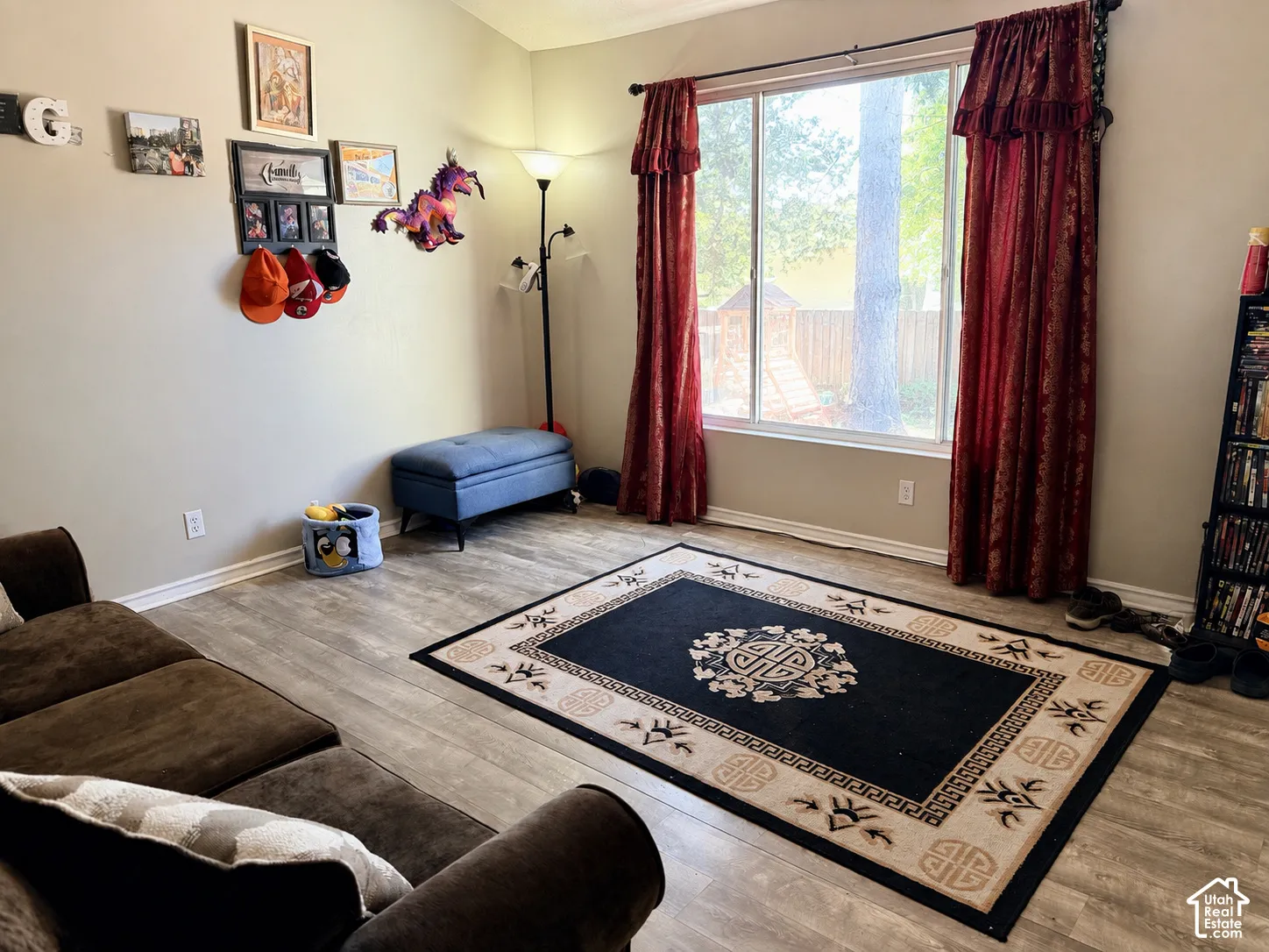 Wood-finish flooring with a large window and red patterned drapery