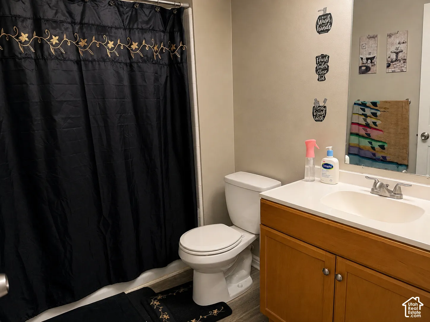 Bathroom with wood-finish vanity, integrated sink, and brushed nickel fixtures