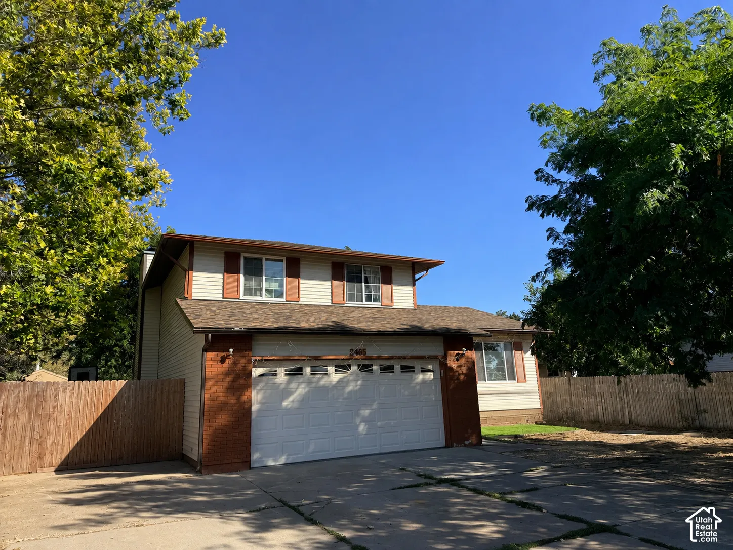 Two-story residence with a dual garage door and a shingled roof