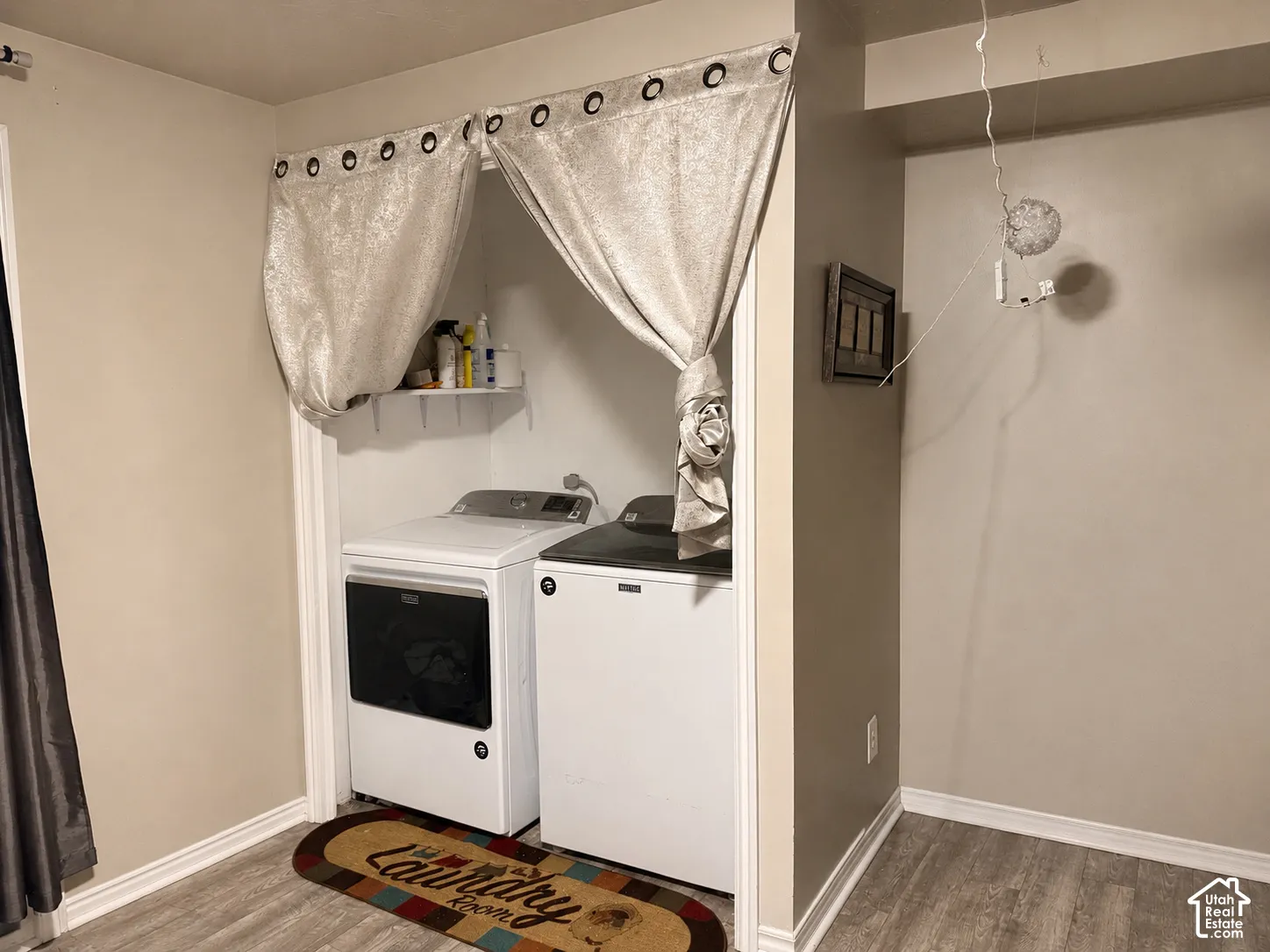 Laundry area with built-in shelving and wood-finish flooring