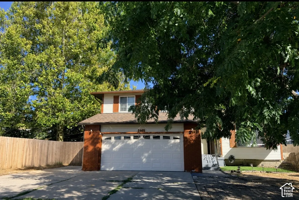 Two-story residence featuring brick and siding facade, an attached garage, and a concrete driveway