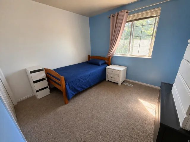 Carpeted room featuring a window with blinds, and white painted walls