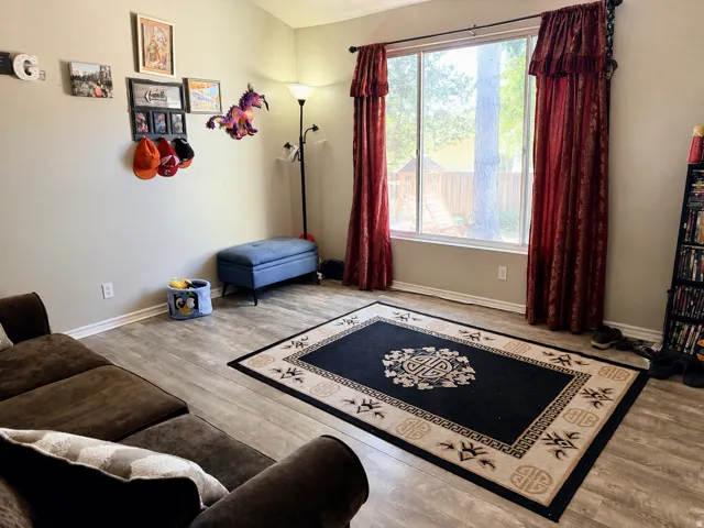 Wood-finish flooring with a large window and red patterned drapery