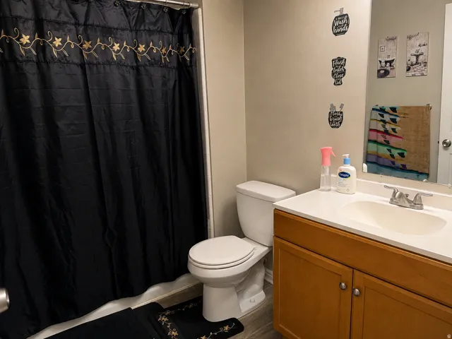Bathroom with wood-finish vanity, integrated sink, and brushed nickel fixtures