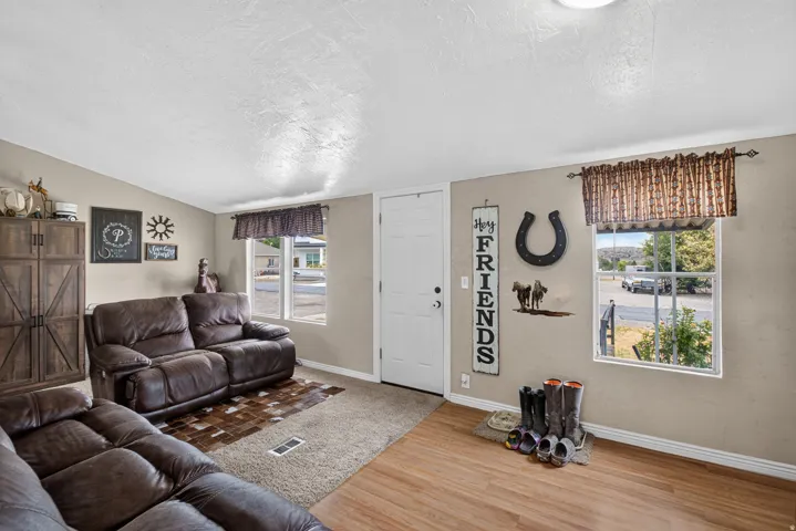 Vaulted ceiling with an attached light fixture, a wood-finish flooring entry, and a carpeted living area