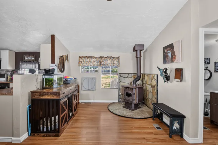 Wood-finish flooring throughout, featuring a wood-burning stove with stone surround