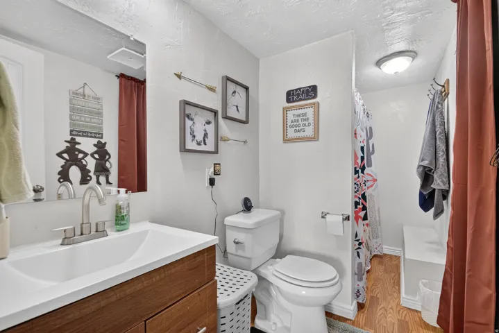 Vanity with wood-finish cabinetry, white countertop, and integrated sink