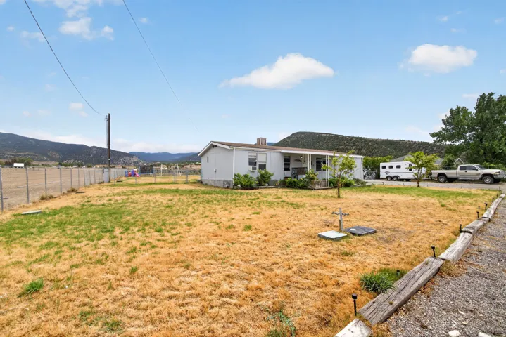 Front yard featuring a gravel driveway and a partial chain-link fence