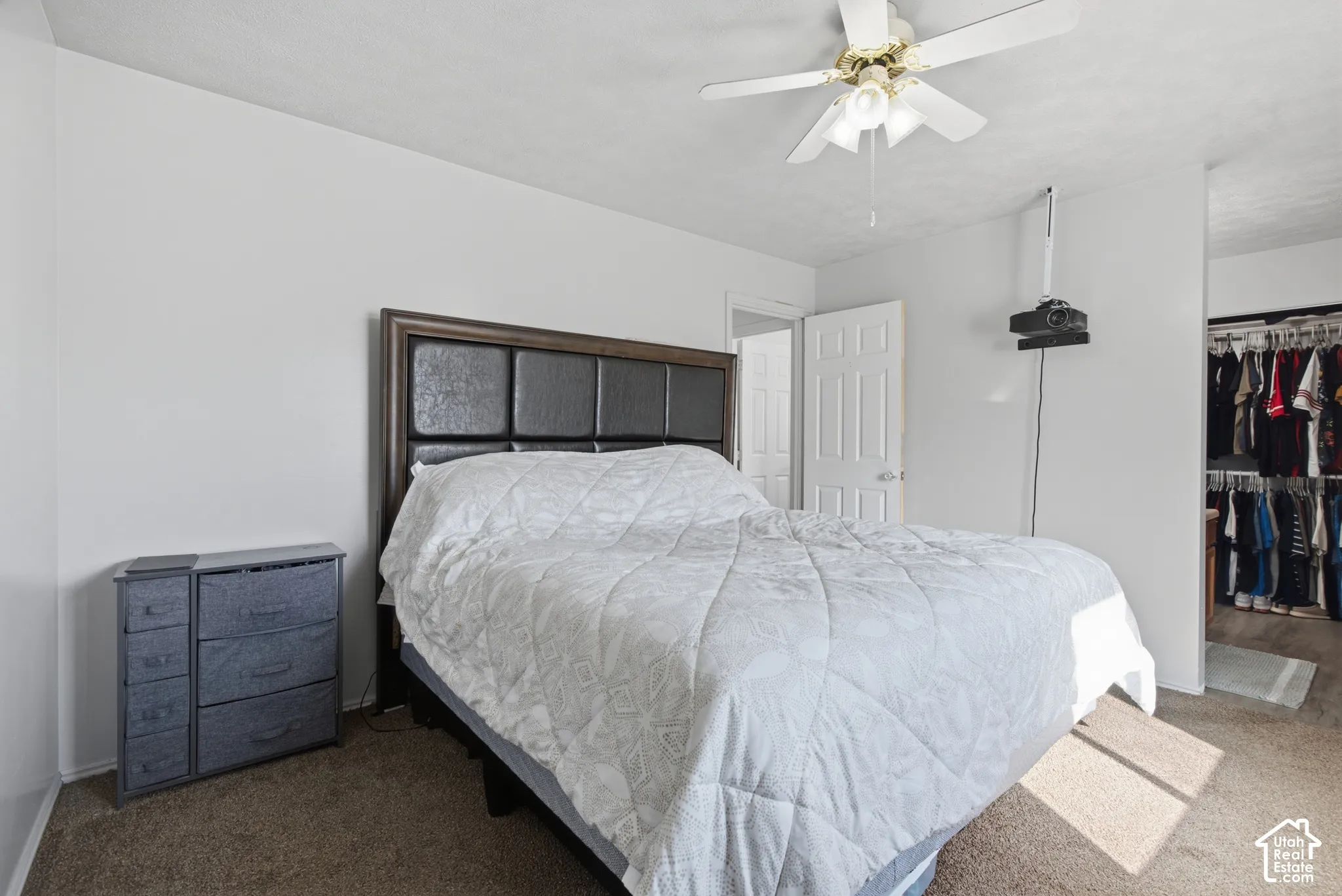 Carpeted flooring, white interior walls, and a ceiling fan with integrated lighting