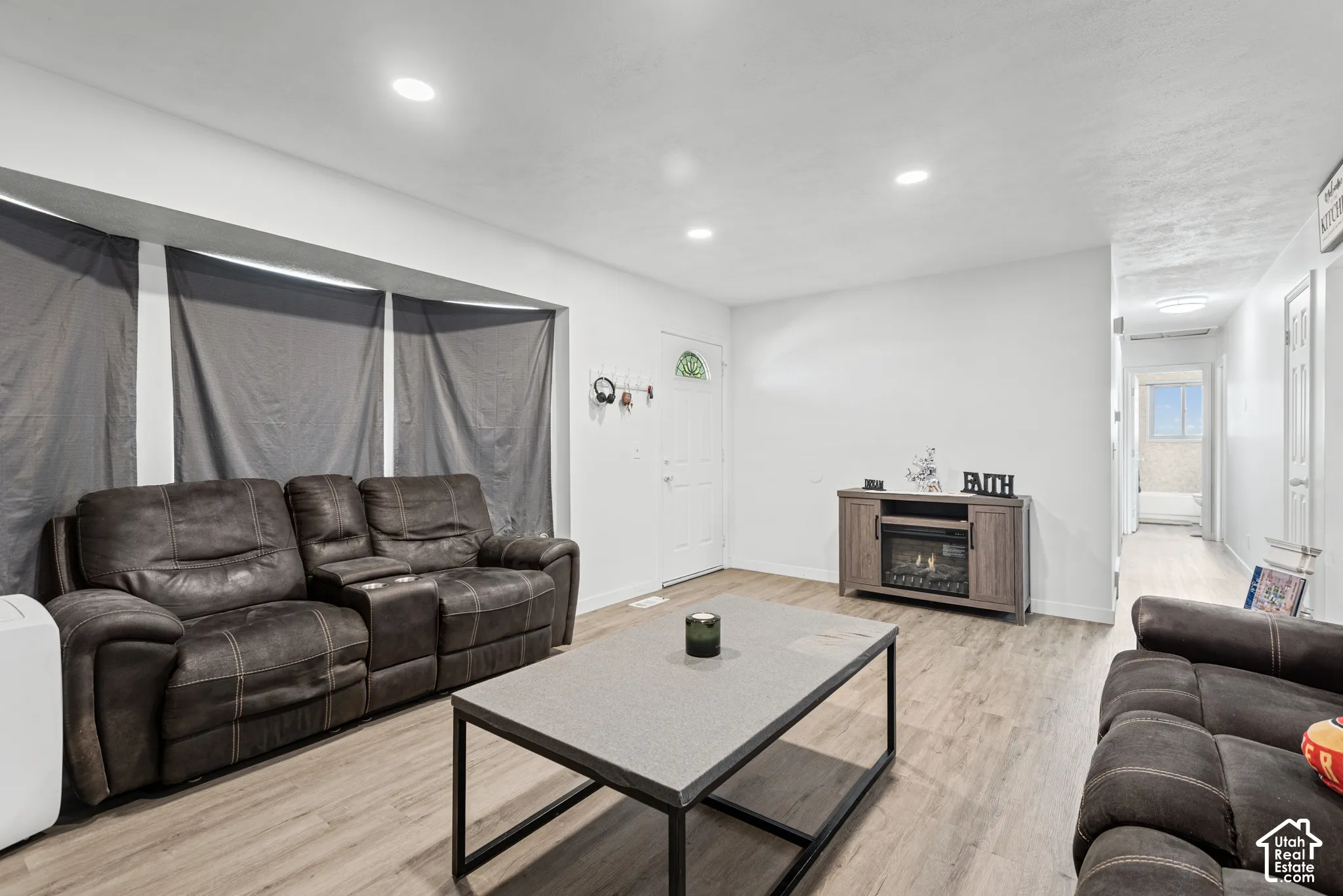 Recessed lighting, wood-finish flooring, white walls, and a front entry door with an arched window