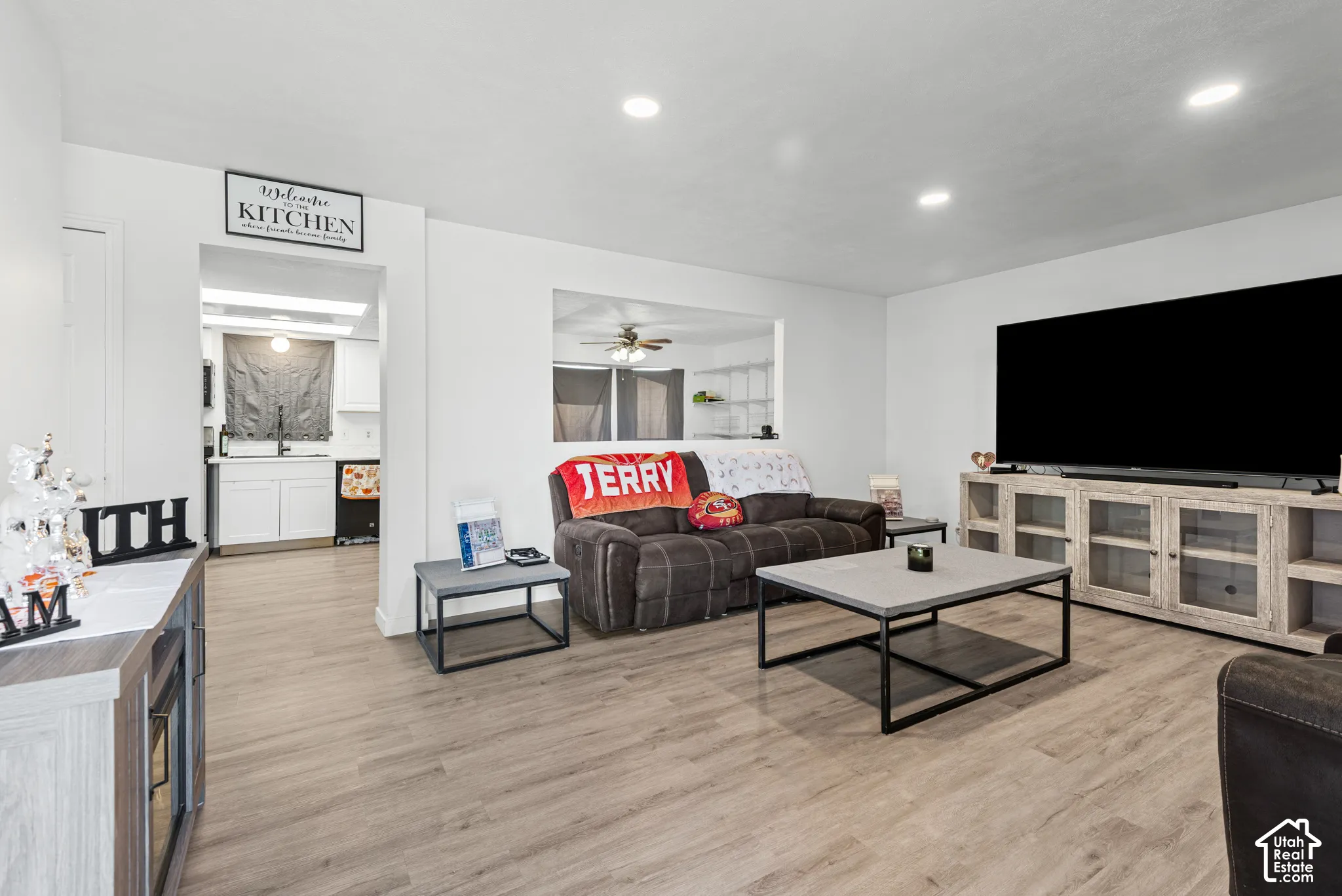 Wood-finish flooring throughout, recessed lighting, and a pass-through window to the kitchen