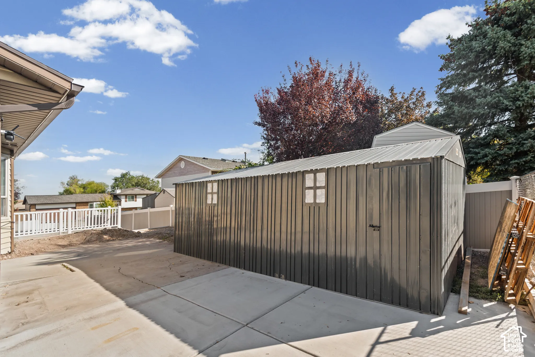 Detached storage shed with a metal roof and panel siding