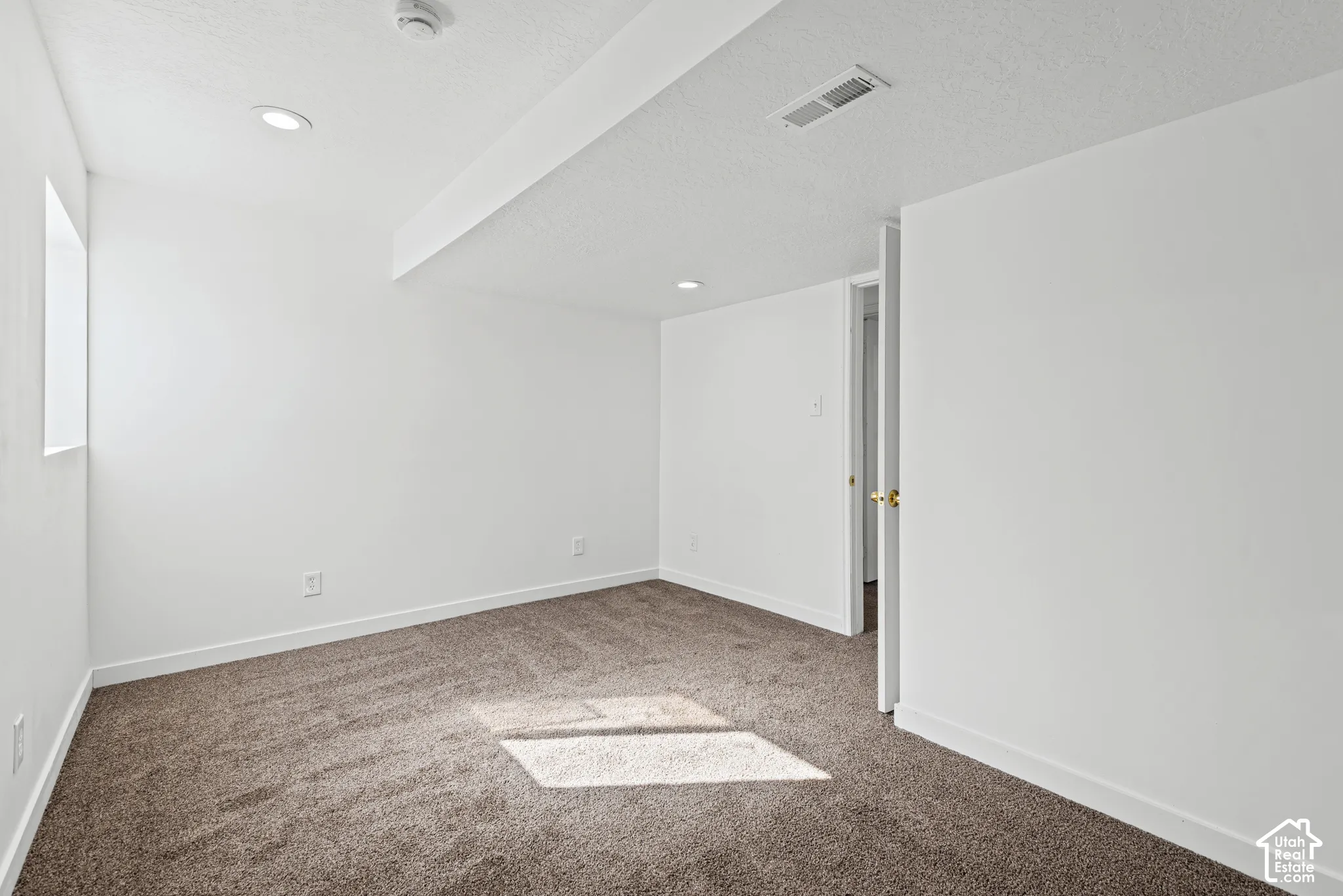 Recessed ceiling lighting, textured ceiling finish, neutral carpet flooring, white wall paint, and white trim