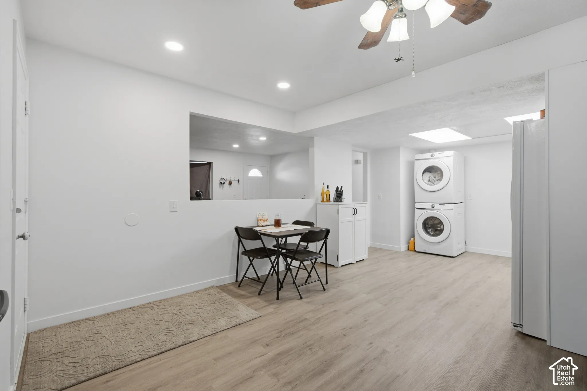 Recessed ceiling lighting, wood-finish flooring, white walls, built-in cabinetry, and a ceiling fan