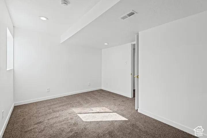 Recessed ceiling lighting, textured ceiling finish, neutral carpet flooring, white wall paint, and white trim